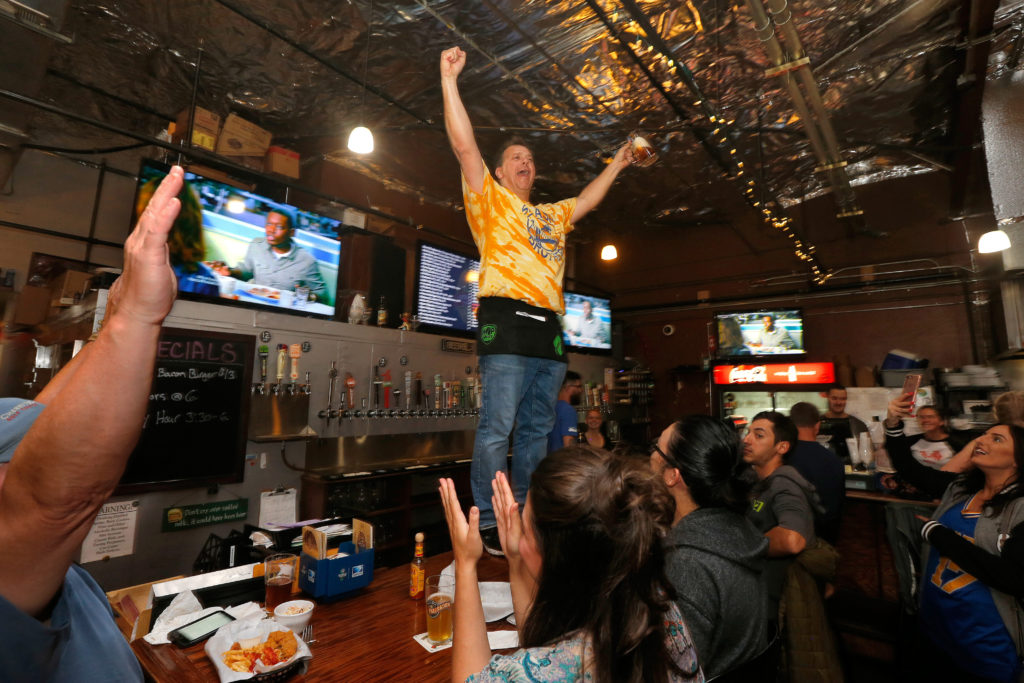 Bar owner Kevin Sprenger stands atop his bar singing, "We are the Champions," as he and other Warriors fans celebrate the team's NBA championship victory over the Cleveland Cavaliers at Sprenger's Taproom in Santa Rosa, California, on Monday, June 12, 2017. (Alvin Jornada / The Press Democrat)
