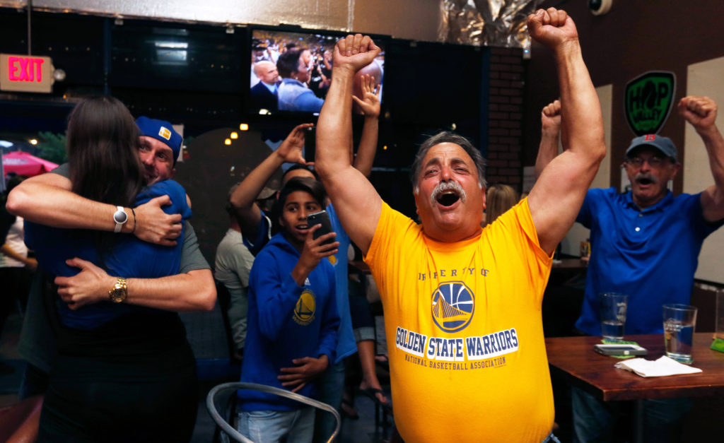 Warriors fans Mike Bell, center and his friend Dave Murphy, right, both of Sebastopol, cheer with other local fans as they celebrate the Warrior's NBA championship victory over the Cleveland Cavaliers at Sprenger's Taproom in Santa Rosa, California, on Monday, June 12, 2017. (Alvin Jornada / The Press Democrat)
