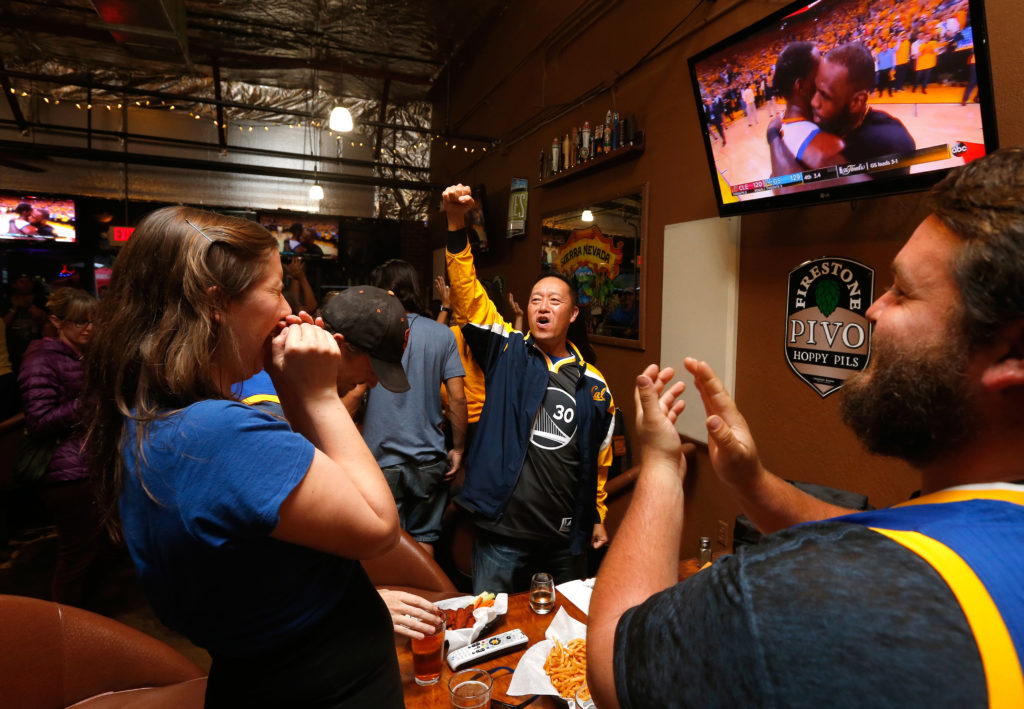 Warriors fans Erin Brierly, left, Nicholas May, Bruce Chin and Brian Shield celebrate the team's NBA championship victory in game 5 over the Cleveland Cavaliers, at Sprenger's Taproom in Santa Rosa, California, on Monday, June 12, 2017. (Alvin Jornada / The Press Democrat)