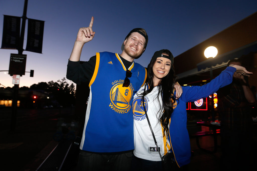Golden State Warriors fans Tyler Ross and Christina Haggin are all smiles after the Warriors' victory over the Cleveland Cavaliers in game 5 of the NBA Finals, at Sprenger's Taproom in Santa Rosa, California, on Monday, June 12, 2017. (Alvin Jornada / The Press Democrat)
