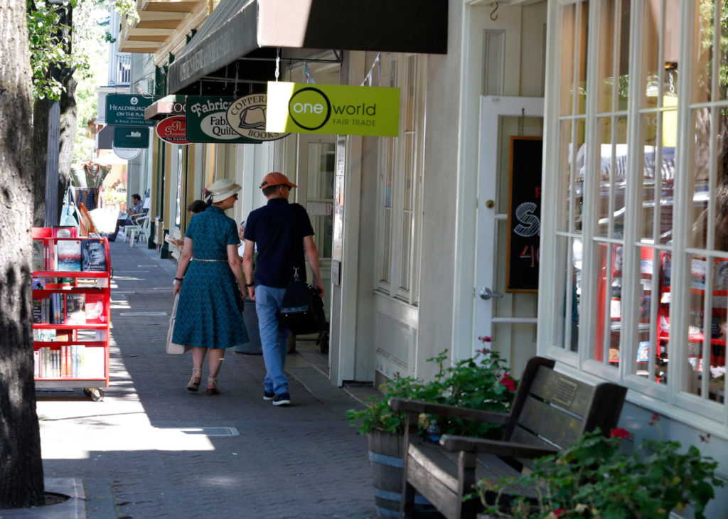 A couple window shops outside the stores occupying a building along Matheson Street that is being purchased by a developer who is considering building a hotel on the property in Healdsburg, California on Wednesday, July 26, 2017. (Alvin Jornada / The Press Democrat)