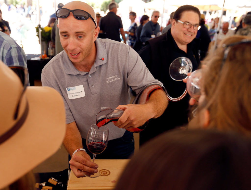 Trione Vineyards and Winery assistant tasting room manager Reed Ackerman pours a Trione 2013 Syrah Russian River Valley for guests from a unique decanter made by Riedel in 2010 to represent the Year of the Dragon, during the North Coast Food and Wine Festival at Sonoma Mountain Village in Rohnert Park, California, on Saturday, June 10, 2017. (Alvin Jornada / The Press Democrat)