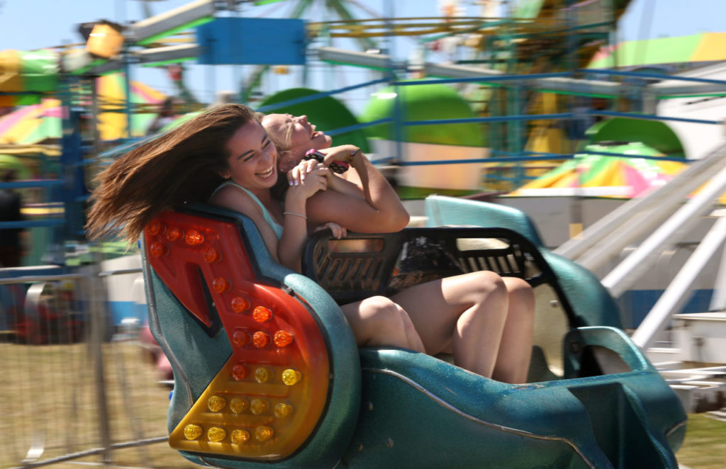 6/20/2013: B1: PC: Victoria Dobbins, left, and Danielle Codding laugh as they spin around on a ride at the Sonoma-Marin Fair, in Petaluma, on Wednesday, June 19, 2013. (Christopher Chung/ The Press Democrat)