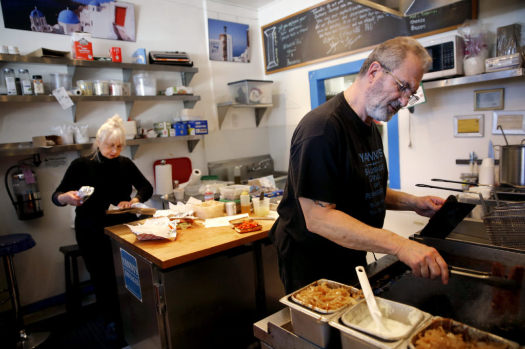 John and Francesca Vrattos work to fill lunch orders during the last day of business at Yanni's Sausage Grill on Sunday, February 25, 2018 in Penngrove, California . (BETH SCHLANKER/The Press Democrat)
