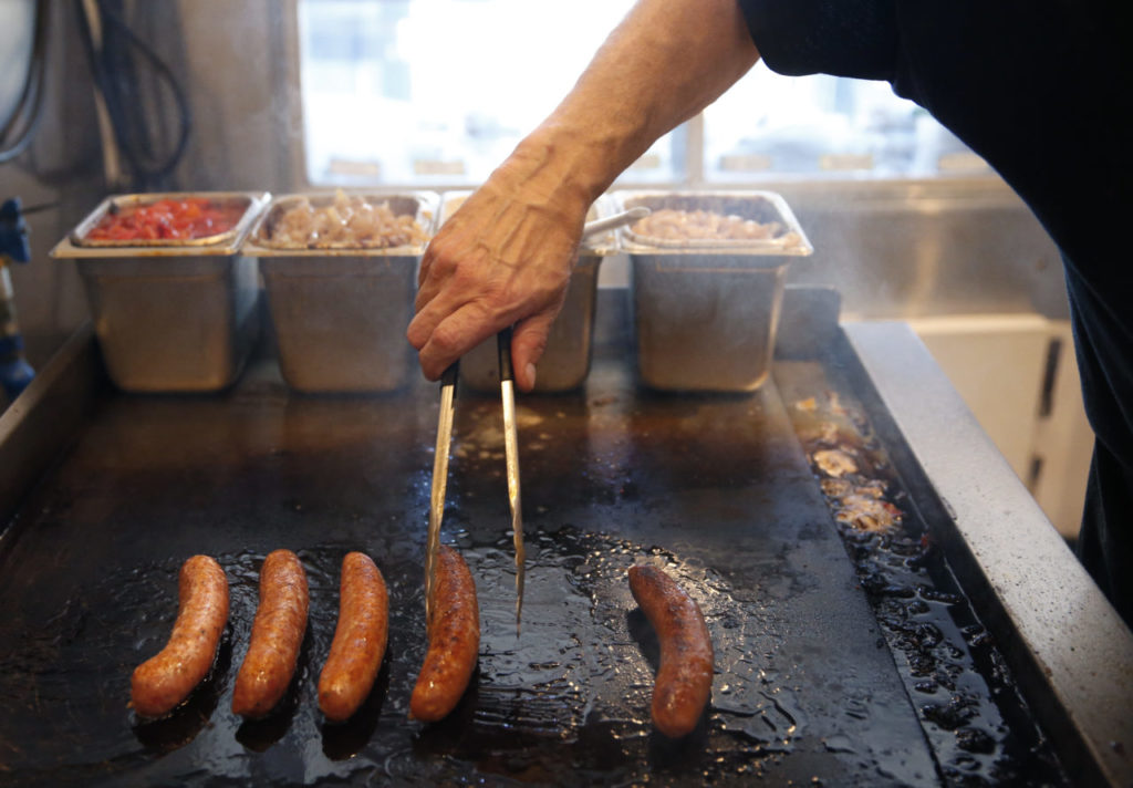 John Vrattos cooks sausages during the last day of business at Yanni's Sausage Grill on Sunday, February 25, 2018 in Penngrove, California . (BETH SCHLANKER/The Press Democrat)