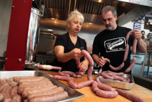 11/28/2012: D1: PC: Yanni's Sausage Grill owners John (Yanni) Vrattos, right, and his wife, Francesca make their links on Monday and Tuesday for the overflow crowd at their tiny store on Main St. in Penngrove. (John Burgess/The Press Democrat)