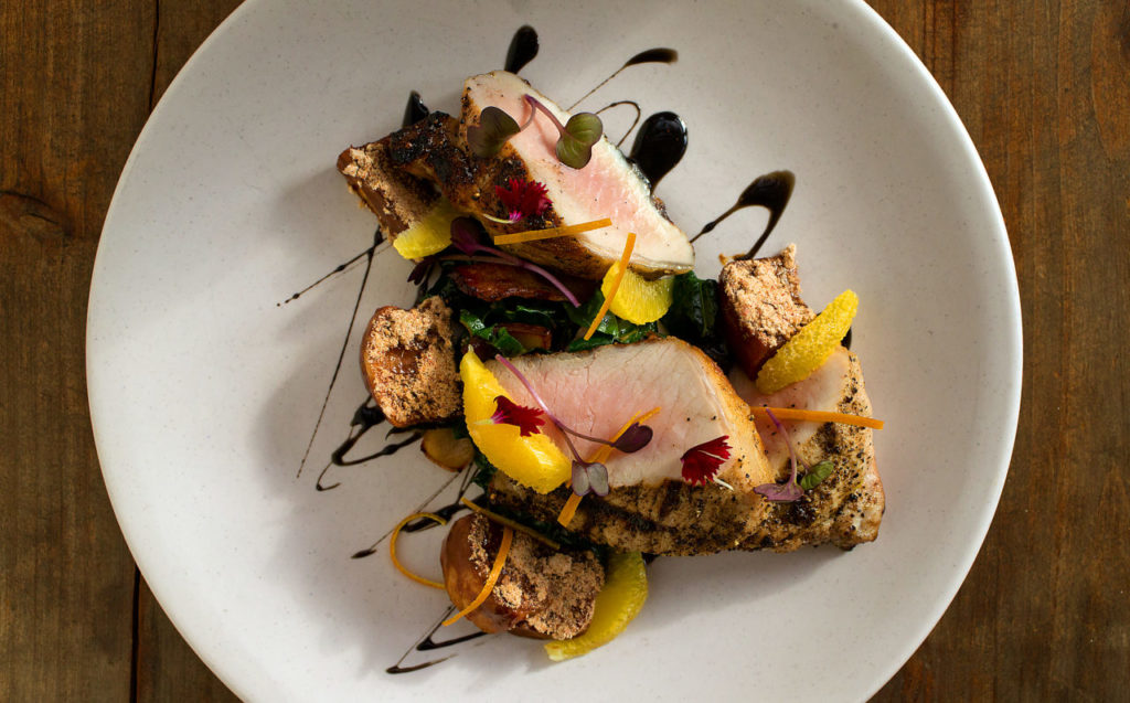 Grilled Pork Chop with coriander carmelized turnips, bacon, braising greens, oranges & squid ink from the Russian River Vineyards Restaurant & Farm in Forestville. (photo by John Burgess/The Press Democrat)