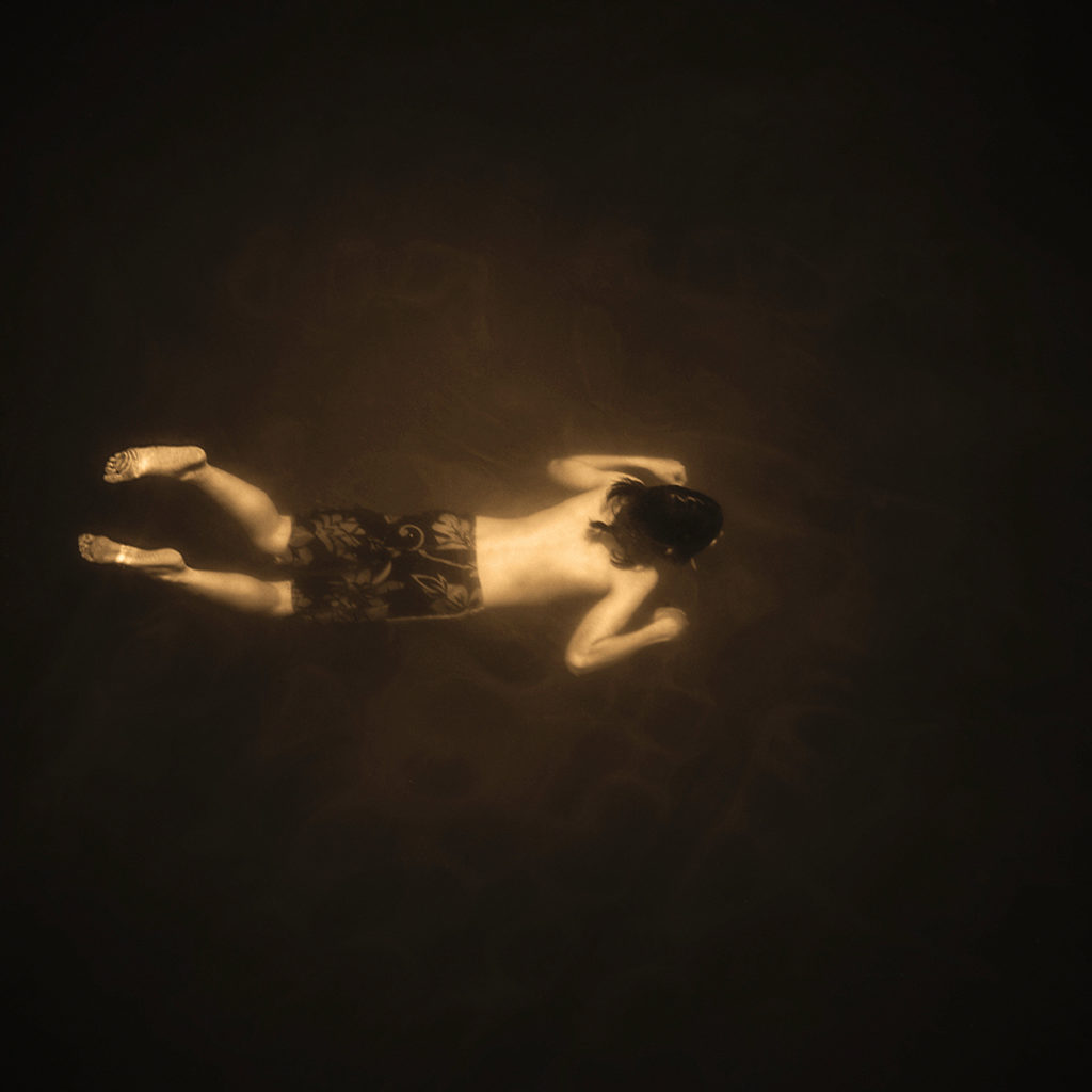 Looking down on a boy swimming underwater in the Russian River.