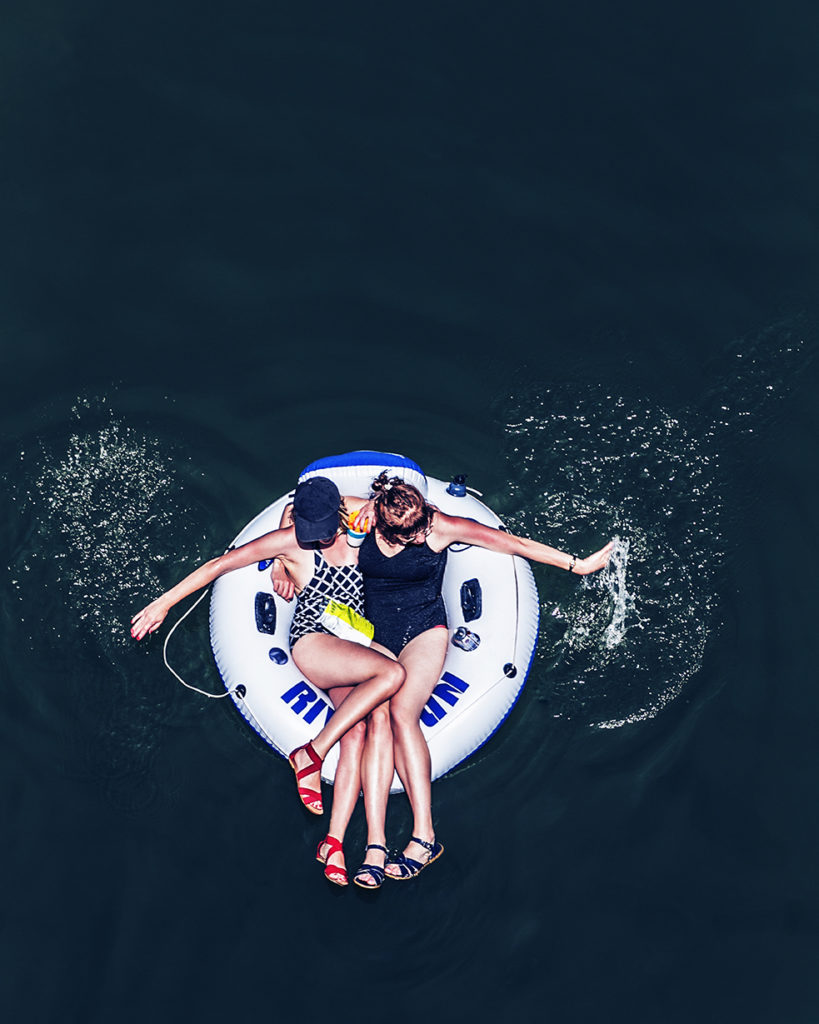 Looking down on two women floating in an inner tube on the Russian River.