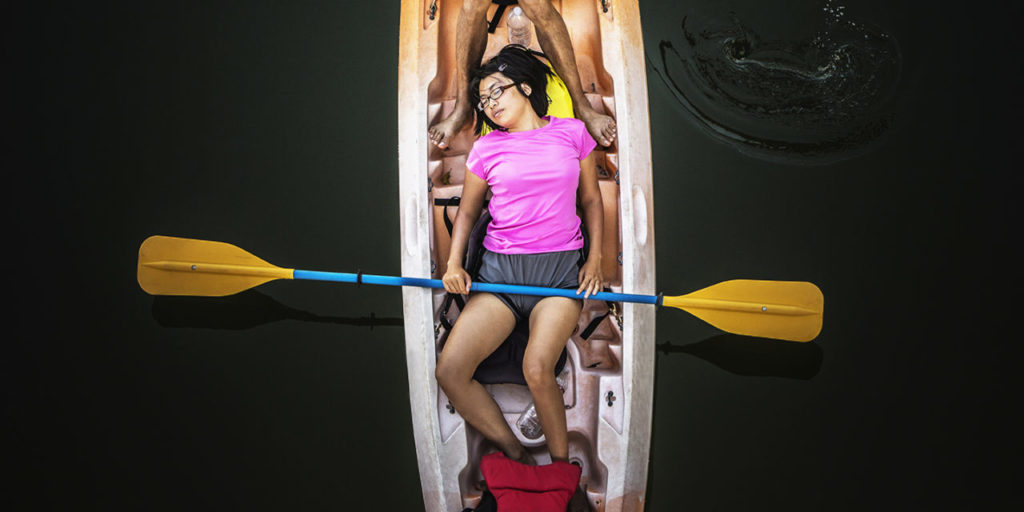 Looking down on a woman asleep in a canoe on the Russian River in Monte Rio, California.