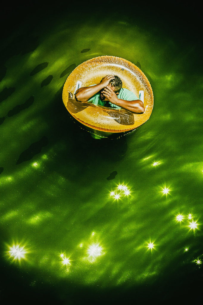 Top view of a man in the middle of an inner tube on the Russiaan River in Monte Rion, California.Digital grain has been added to this image.
