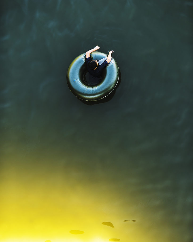 Looking down of a boy floating on a inner tube oin the Russian River in Monte Rio, California.