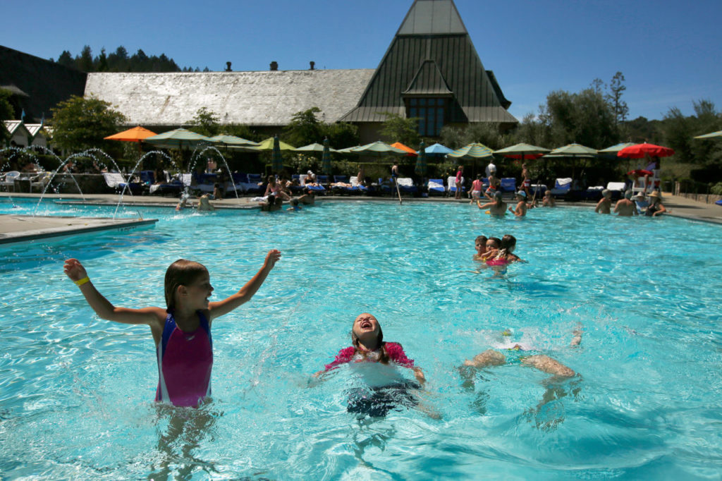 Young friends Macy Carver, 6, left, Kaitlyn Kirk, 7, and Rachel Kirk, 9, all from San Francisco, practice their backflips in the swimming pool at Francis Ford Coppola Winery in Geyserville, California, on Sunday, August 13, 2017. (Alvin Jornada / The Press Democrat)