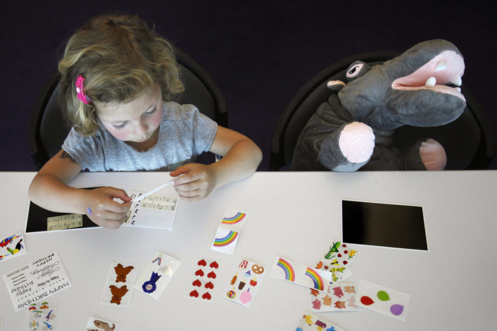 Sarah Hughes, 4, joined by Sally the Hippo use stickers to create an art project at the end of the tour at Mrs. Grossman's sticker factory on Wednesday, April 27, 2011, in Petaluma, California. (BETH SCHLANKER/ The Press Democrat)