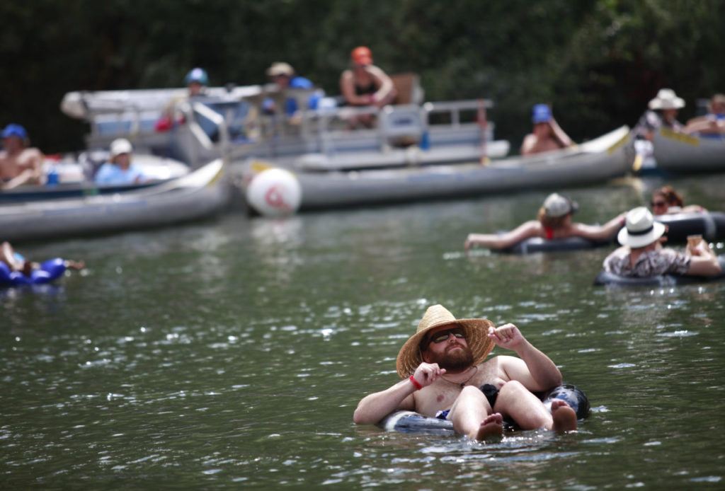 Paul Kennelly moves his arms to the music of Goapele as he sits in an inner tube at the Russian River Jazz and Blues Festival at Johnson's Beach on Saturday, September 20, 2014 in Guerneville, California. (BETH SCHLANKER/ The Press Democrat)