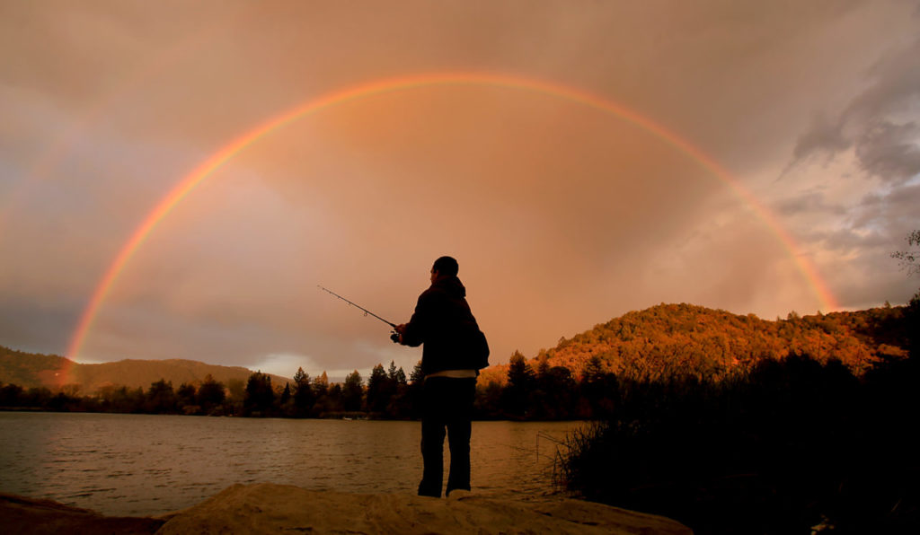 Alex Hamann of Santa Rosa fishes under a rainbow at Spring Lake, as a storm rolls through Santa Rosa, Monday Nov. 2, 2015. (Kent Porter / Press Democrat) 2015