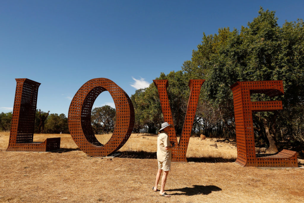 Jewels Drury of Calistoga stands beside the iconic "Love" sculpture, during the reopening of the sculpture garden at Paradise Ridge Winery in Santa Rosa, California, on Saturday, July 7, 2018. (Alvin Jornada / The Press Democrat)