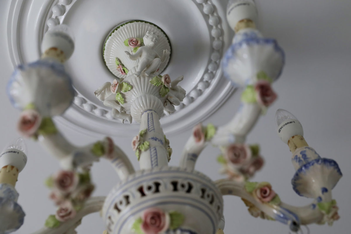 An antique porcelain light hands in a room of The Francis House. Each room features a different vintage overhead lamp. (Christopher Chung/ The Press Democrat)