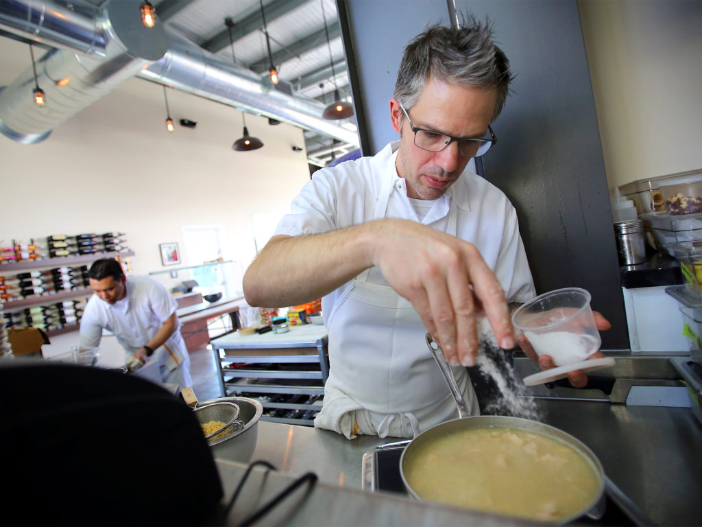 Mark Hopper, owner and chef at Vignette, puts salt in his casserole made from earthquake kit ingredients, in Sebastopol on Thursday, October 2, 2014. (Christopher Chung/ The Press Democrat)