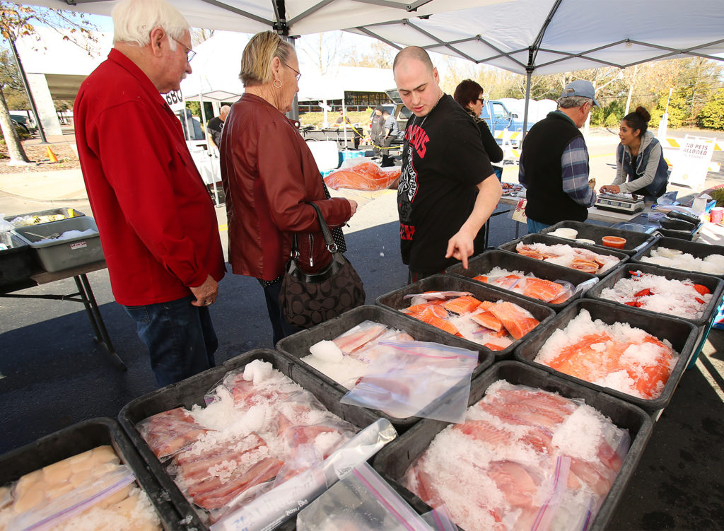 Sal Svedise from Santa Rosa Seafood, center, sells fresh fish, crabs and shellfish at the last of the year's Windsor Farmers Market in the Town Green on Sunday, December 15, 2013. (Conner Jay/The Press Democrat)