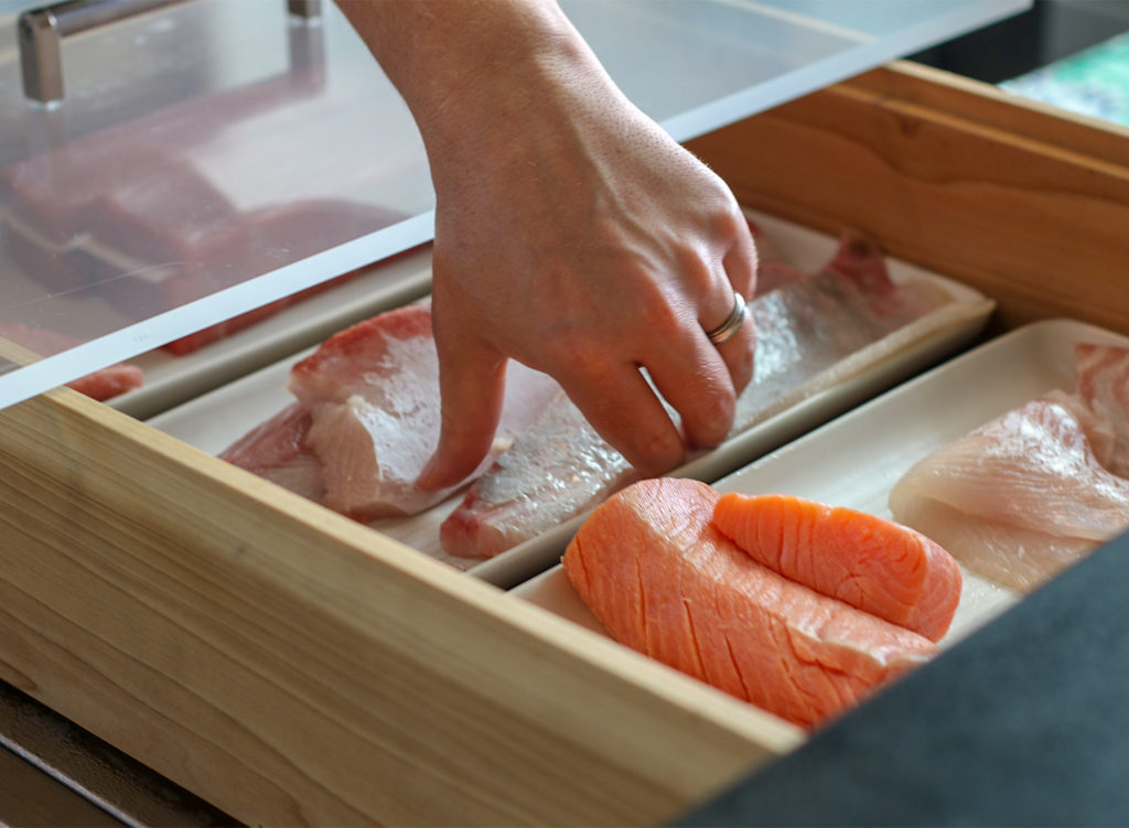 Chef Jake Rand picks up raw fish for sushi at Kosho restaurant in Sebastopol. Heather Irwin/PD