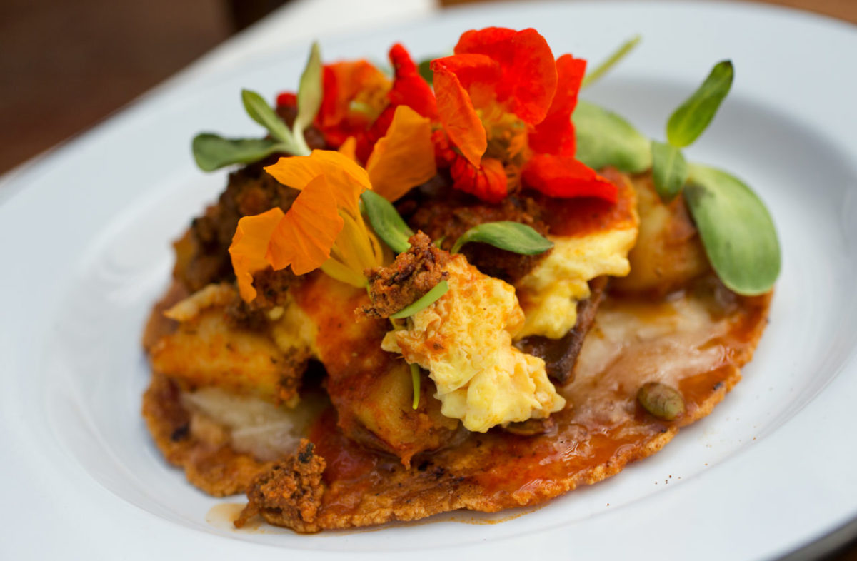 The Choriloco with red corn tortilla, potatoes, handmade chorizo, scrambled eggs, pumpkin seed, melted cheese curds, arugula and salsa de chile Morita from Barrio Fresca Cocina Mexicana in Sebastopol's The Barlow. (John Burgess / The Press Democrat)