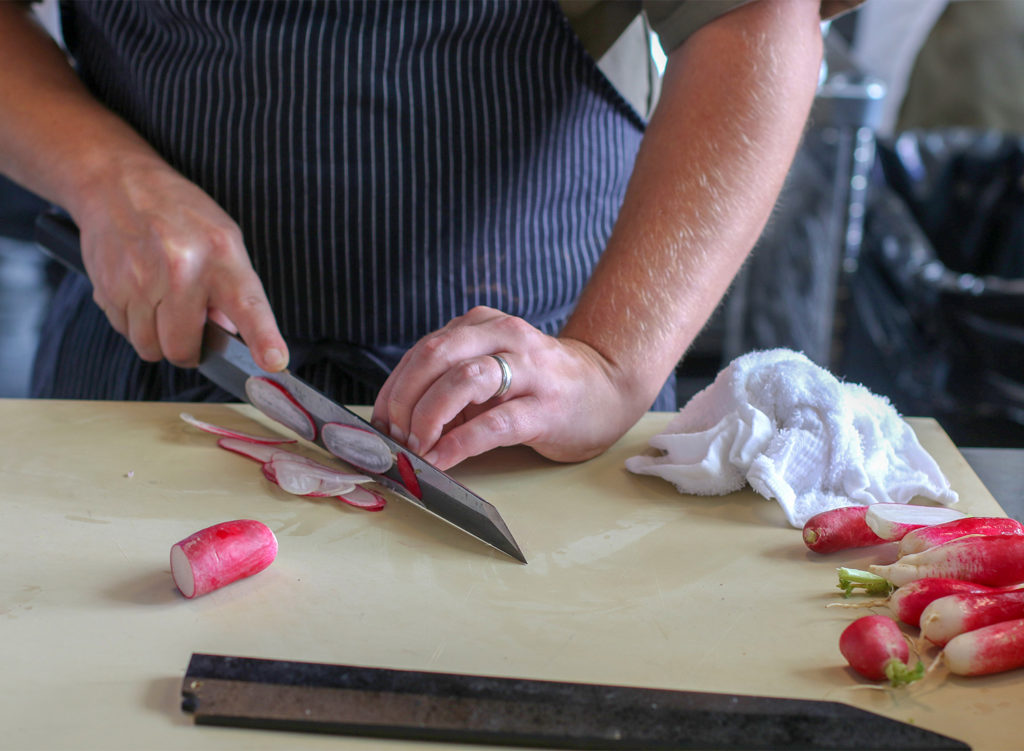 Chef Jake Rand cutting radish at Sushi Kosho in Sebastopol. Heather Irwin/PD