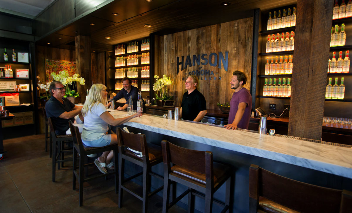 From left behind the bar, Will Papadain, Scott and Brandon Hanson greet guests in the tasting room at the Hanson of Sonoma Distillery. (John Burgess/The Press Democrat)