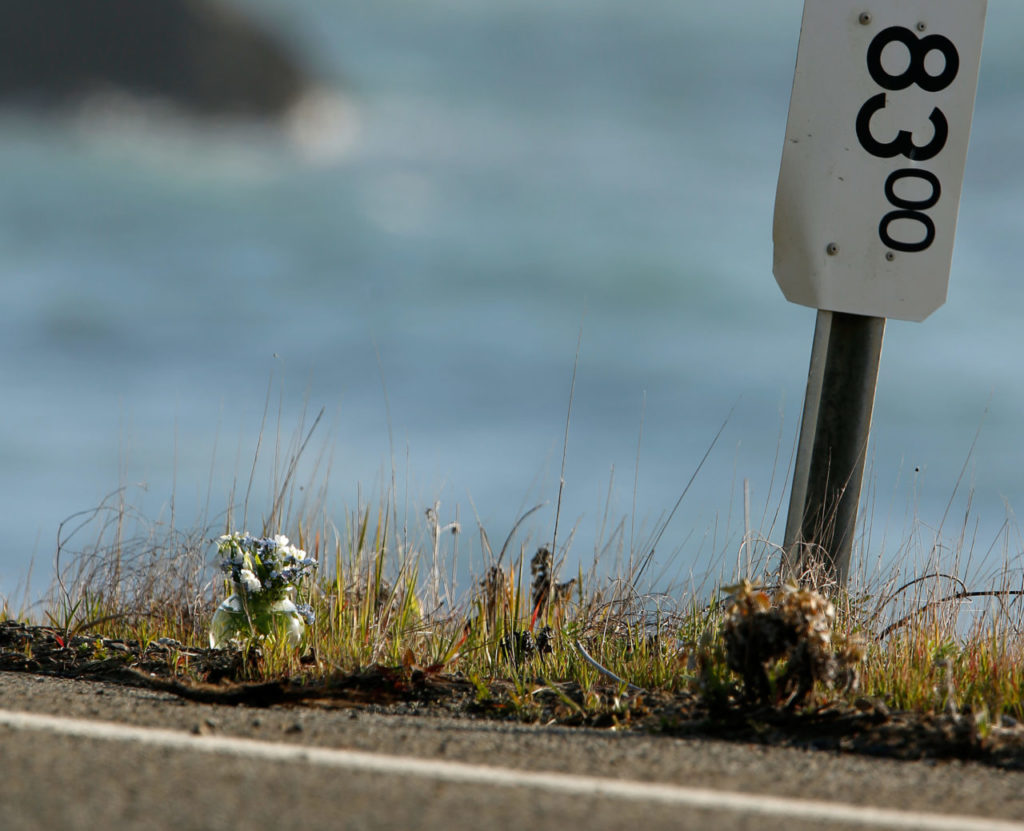 A small vase of flowers, at left, was left beside a mile marker near the pullout where the SUV of Jennifer Jean Hart and Sarah Margaret Hart was recovered, off Highway 1, near Westport, California, on Wednesday, March 28, 2018. The bodies of the two women and three of their adopted children were recovered after the vehicle plunged over the cliff two days earlier, while three more of their children, Devonte Hart, 15, Hannah Hart, 16, and Sierra Hart, 12, are still missing. (Alvin Jornada / The Press Democrat)