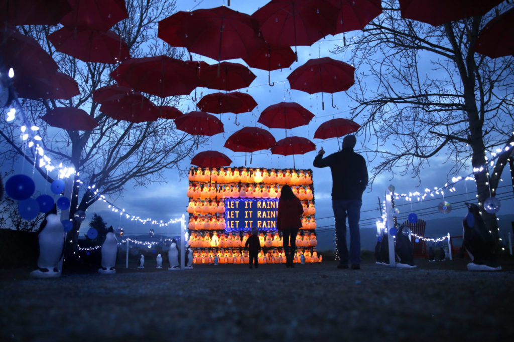 Dylan McCrum, his wife, Katie, and son Elliot, 19-months old, visit the holiday display of lighted snowmen and red umbrellas at CornerStone Sonoma on Tuesday, December 8, 2015 in Sonoma, California . (BETH SCHLANKER/ The Press Democrat)