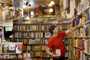 Aaron Rosewater, co-owner of Levin & Company, organizes the shelves at his bookstore in Healdsburg on Tuesday, August 21, 2018. (Beth Schlanker/ The Press Democrat)