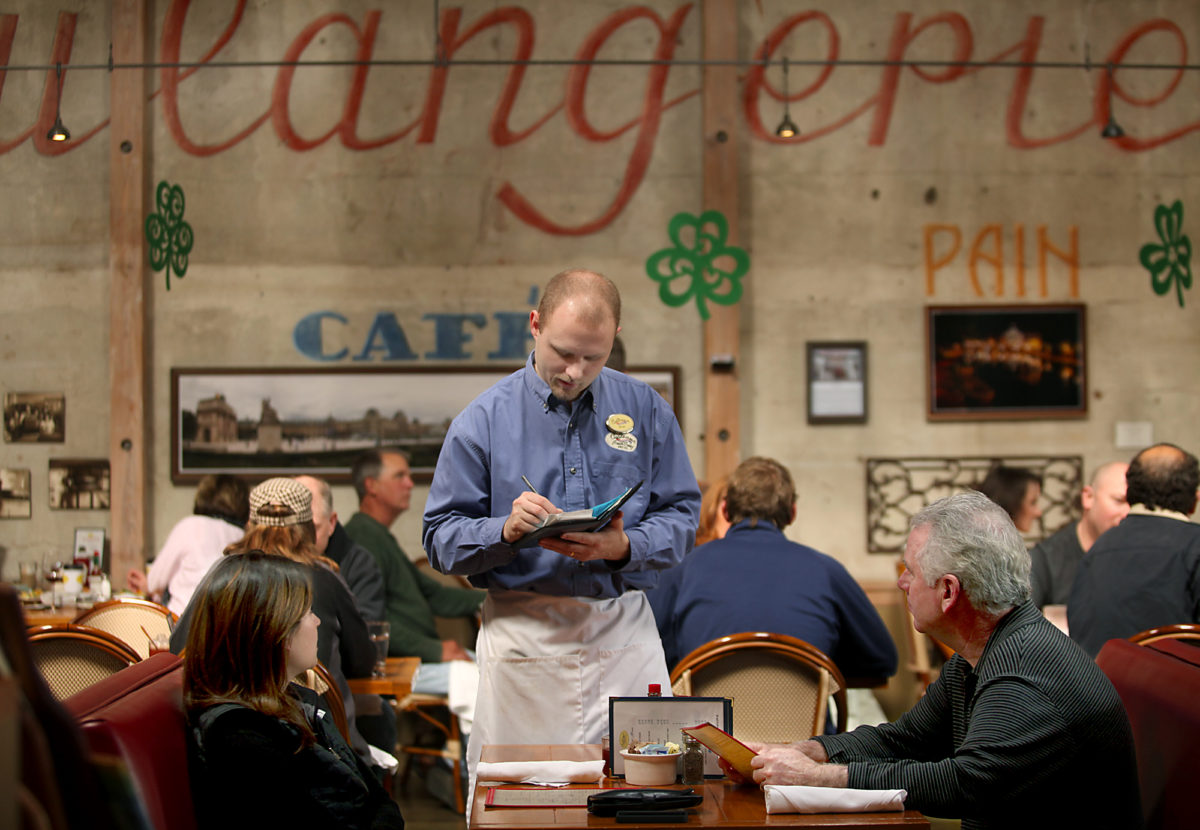 At Costeaux French Bakery in Healdsburg, Brian Phipps takes a food order from father and daughter diners, Pat Dugan, right and Kelly Dugan left. (Kent Porter/The Press Democrat)