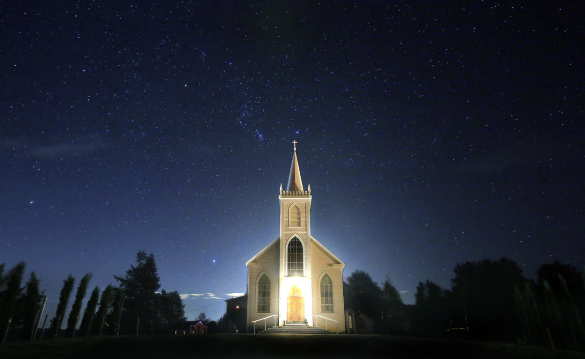 Saint Teresa of Avila Roman Catholic Church in Bodega is illuminated by a single strand of lights around the doorway under the winter hue of a cold clear night, Tuesday Dec. 20, 2016. (Kent Porter / The Press Democrat) 2016
