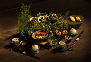 The guest is greeted with an array of dishes presented on a bed of wood, moss and ferns at Single Thread Farms Restaurant in Healdsburg. (John Burgess/The Press Democrat)