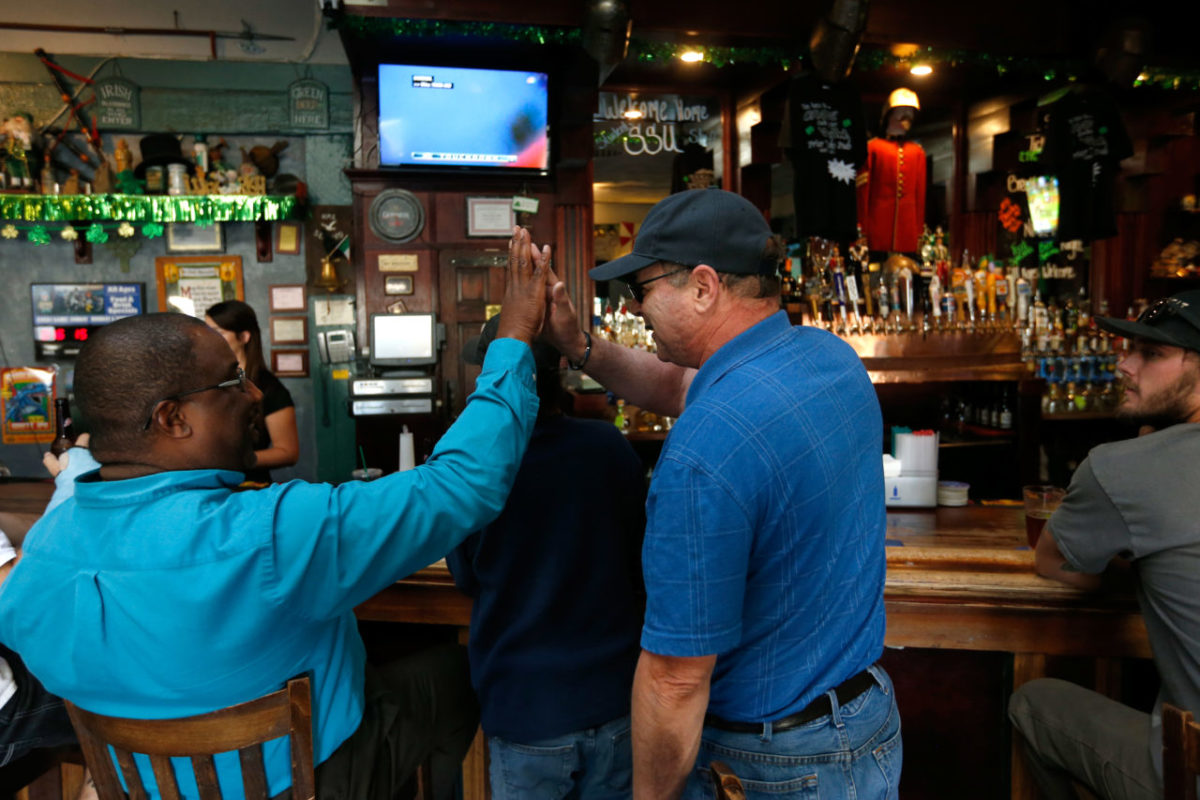 Sam Pearlman, right, a Miami Dolphins fan since 1970, high-fives Fred Coleman while they watch a football game between the Miami Dolphins and Atlanta Falcons at Friar Tucks Pub in Cotati, California on Thursday, August 25, 2016. (Alvin Jornada / The Press Democrat)