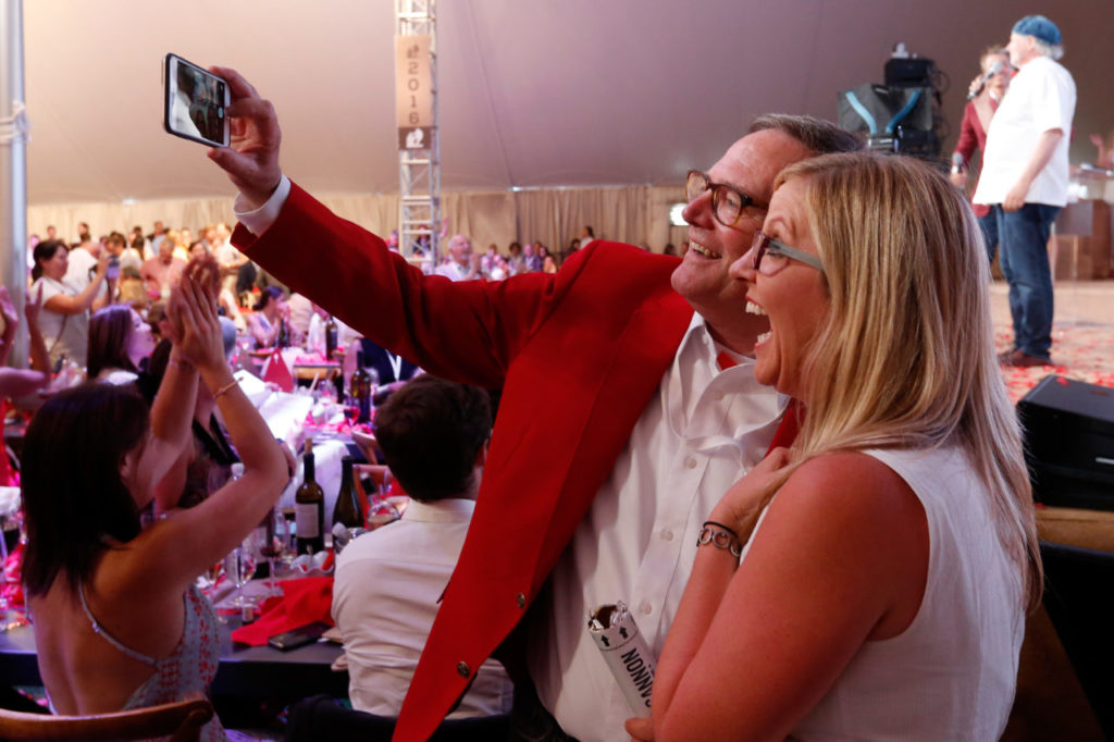 Hoopla committee co-chair Michael Silacci of Opus One snaps a selfie with Amber Mihna of Napa Valley Vintners during Auction Napa Valley at Meadowood in St. Helena, California on Saturday, June 4, 2016. (Alvin Jornada / The Press Democrat)
