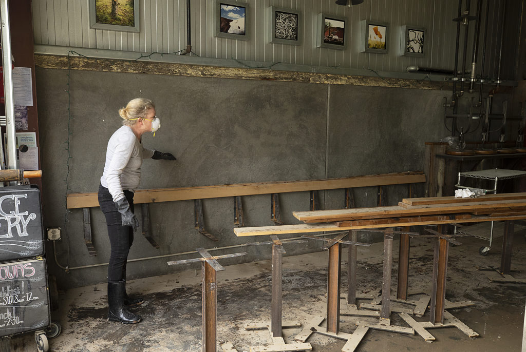 Village Bakery general manager Lisa Schroeder shows an employee how high the water level reach during flooding last week in the Barlow business district in Sebastopol. (photo by John Burgess/The Press Democrat)