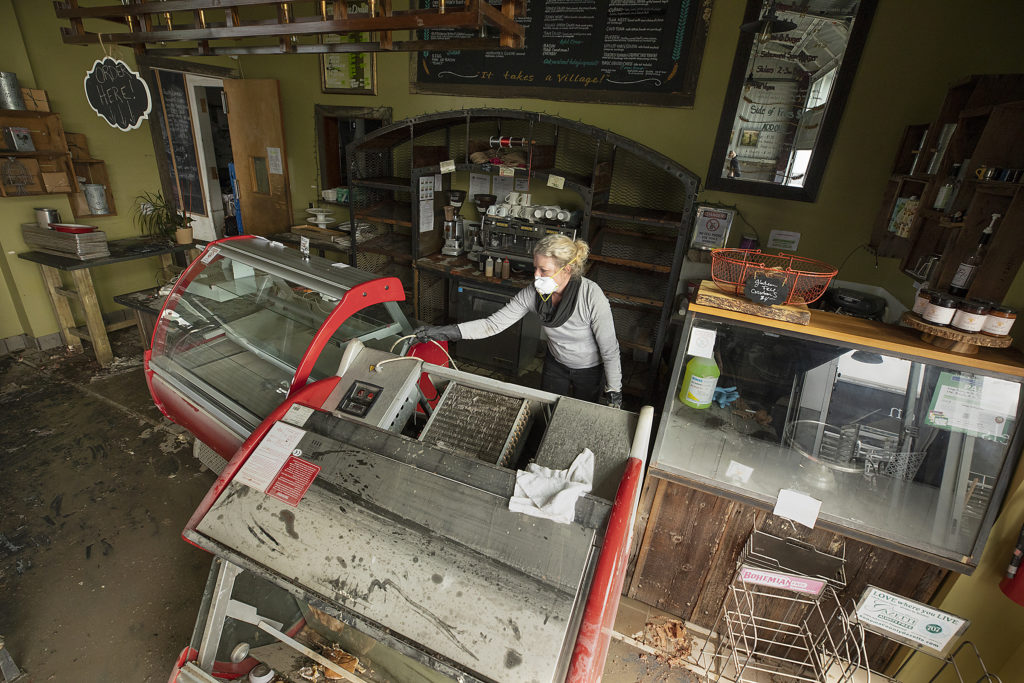 Village Bakery general manager Lisa Schroeder cleans up after last week's flood waters reached about 3 feet in the Barlow business district in Sebastopol on Monday. (photo by John Burgess/The Press Democrat)