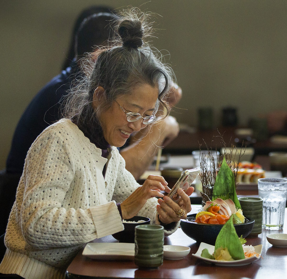 Christie Song takes a photo of her sushi before digging in at Ume Japanese Bistro in Windsor. (John Burgess/The Press Democrat)