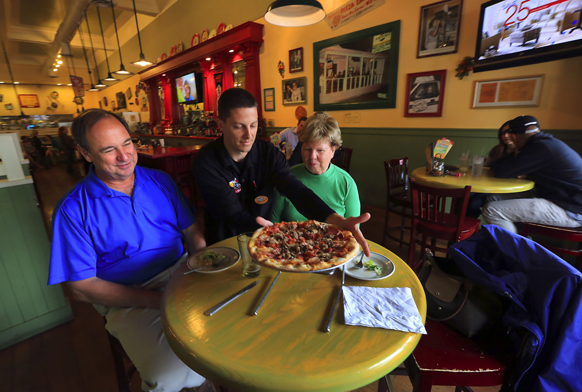 Daniel Hagar delivers a pizza for Dan and Ann Gladding at the downtown Mary's Pizza Shack restaurant during lunch on Thursday. (JOHN BURGESS / Sonoma Magazine)