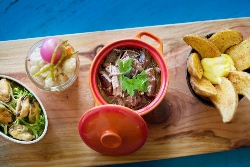 Marinated mussels, marinated vegetables, goat stew with fingerling potatoes and fried piri piri potatoes at Tasca Tasca in Sonoma. (Erik Castro/for The Press Democrat)