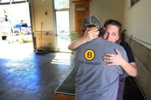 Zazu Kitchen and Farm Duskie Estes embraces Tomas Guzman, part of the maintenance crew of The Barlow, Thursday, April 18, 2019 in Sebastopol. Estes and her husband John Stewart pulled all of their equipment out of the restaurant on Thursday after February flooding of the Laguna shut them down. (Photo by Kent Porter)