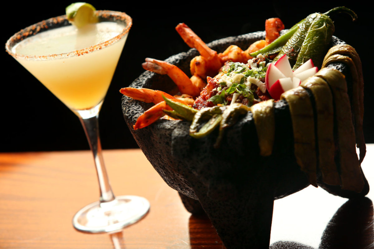 Molcajete, which includes grilled steak, chicken and prawns sauteed with onions in a roasted tomato and chipotle sauce, served with a margarita, at El Farolito in Healdsburg. (Christopher Chung/The Press Democrat)