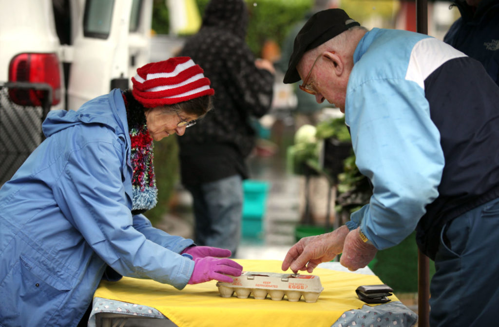 Jacqueline Aubin of Aubin Farms out of Sonoma, sells free range farm fresh eggs to Rene' Dufour of Oakmont during the farmers market in Oakmont.