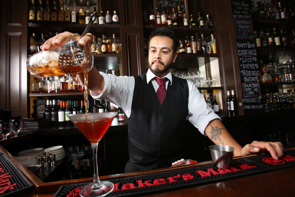 Bartender Neil Espinosa pours a Manhattan as one of Stark's Steakhouse's winter cocktails in Santa Rosa. (Conner Jay/The Press Democrat)