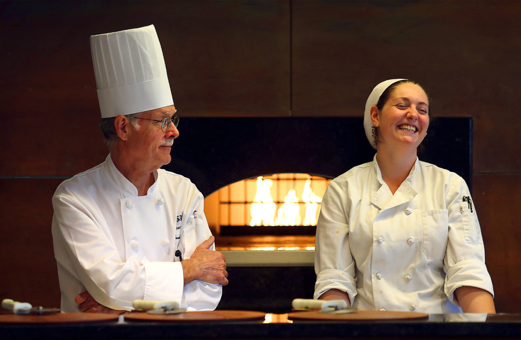 Student Moon Levine, right, laughs at a joke from SRJC Culinary Director Michael Salinger in the pizza kitchen at the SRJC Culinary Cafe. (JOHN BURGESS / The Press Democrat)