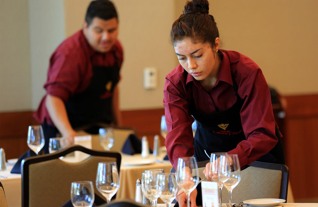 Monica Gomez, right, sets tables before the lunch rush a SRJC's Culinary Cafe. (JOHN BURGESS / The Press Democrat)