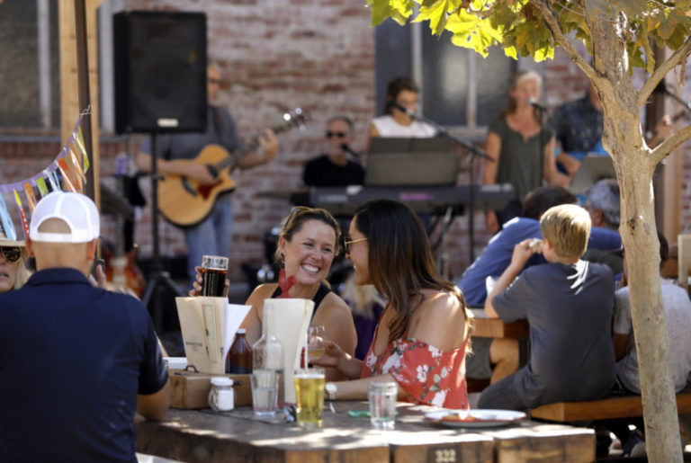 Lynzie Brodhun, left, and her sister Lexi Brodhun drink beer and listen to live music at Brewster's in Petaluma on Sunday, September 9, 2018. (Beth Schlanker/ The Press Democrat)