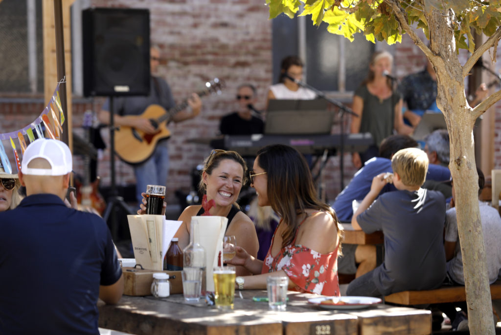 Lynzie Brodhun, left, and her sister Lexi Brodhun drink beer and listen to live music at Brewster's in Petaluma on Sunday, September 9, 2018. (Beth Schlanker/ The Press Democrat)
