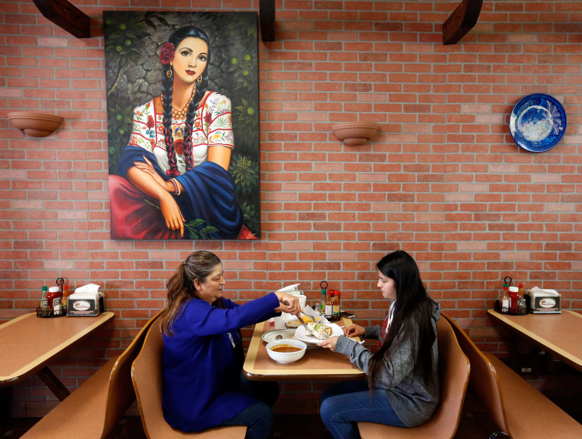 Guadalupe Dominguez, left, and her daughter Myra Mendoza split a super burrito for dinner at Taqueria Molcajetes, in Santa Rosa, on Wednesday, April 25, 2018. (Alvin Jornada / The Press Democrat)